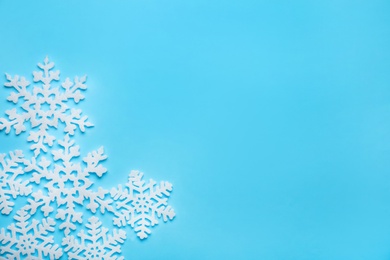 Photo of Beautiful decorative snowflakes on light blue background, flat lay. Space for text