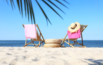 Photo of Wooden sunbeds and beach accessories on sandy shore