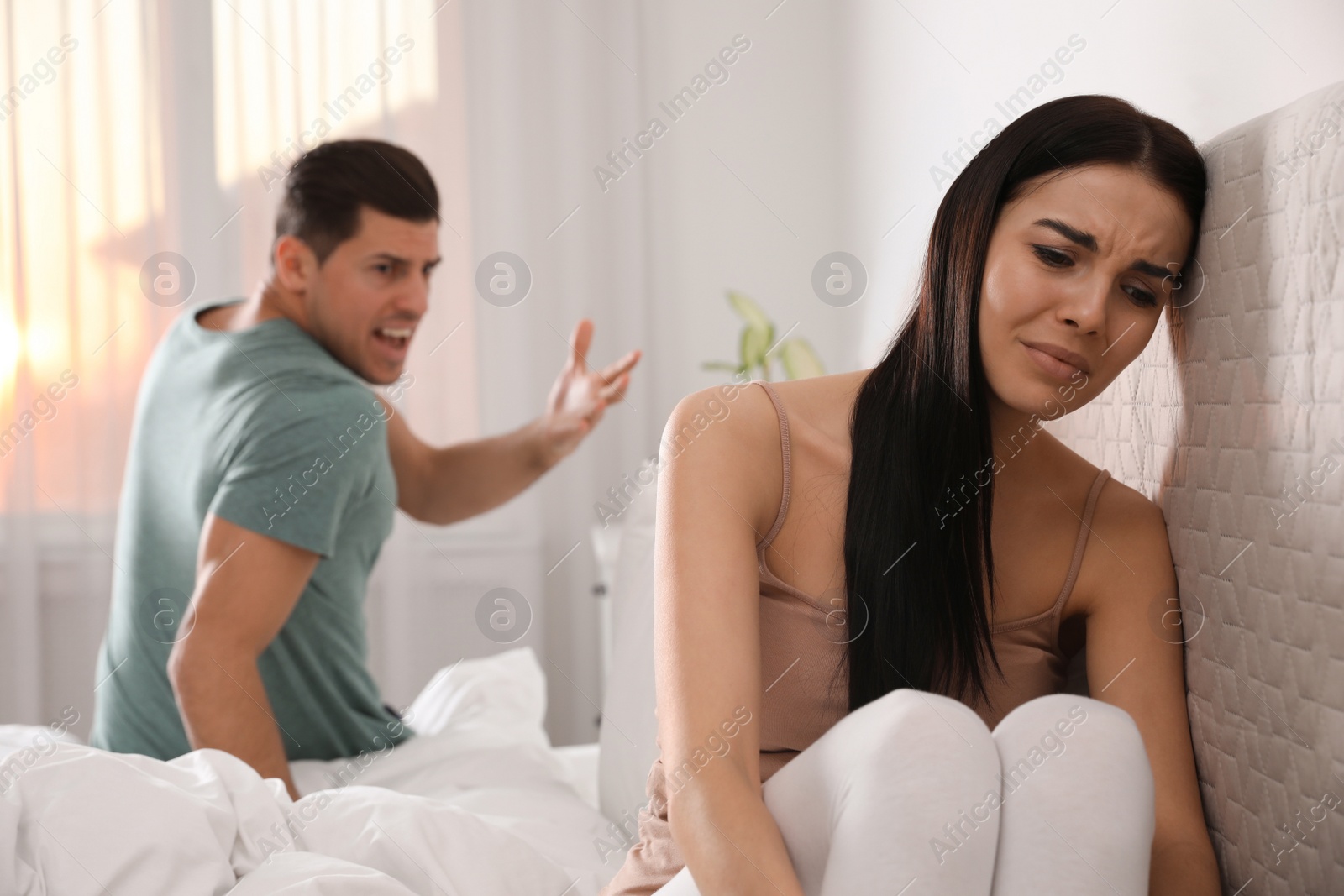 Photo of Couple with relationship problems quarreling in bedroom