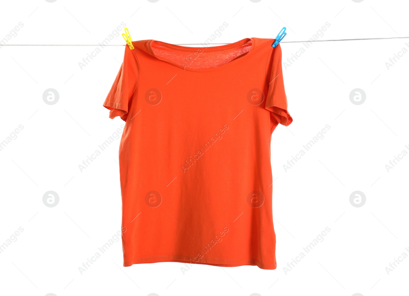 Photo of One orange t-shirt drying on washing line isolated on white