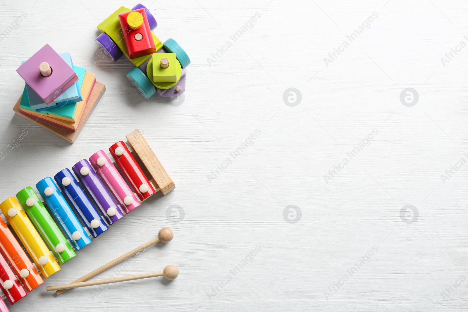 Photo of Different toys on white wooden background, flat lay. Space for text