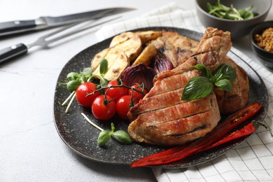 Photo of Delicious grilled meat and vegetables on light grey table, closeup