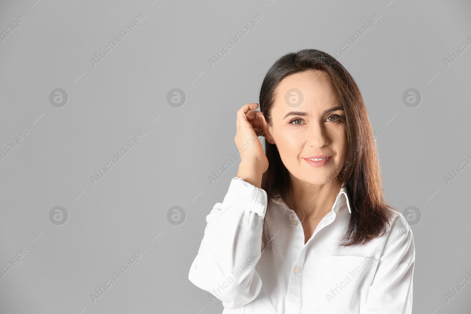 Photo of Portrait of beautiful mature woman on grey background. Space for text