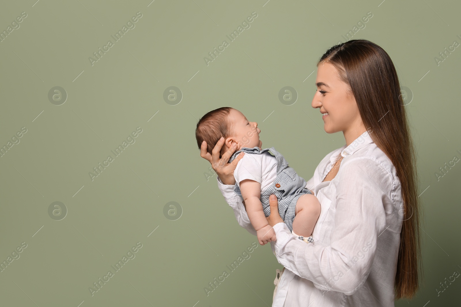 Photo of Mother holding her cute newborn baby on olive background, space for text