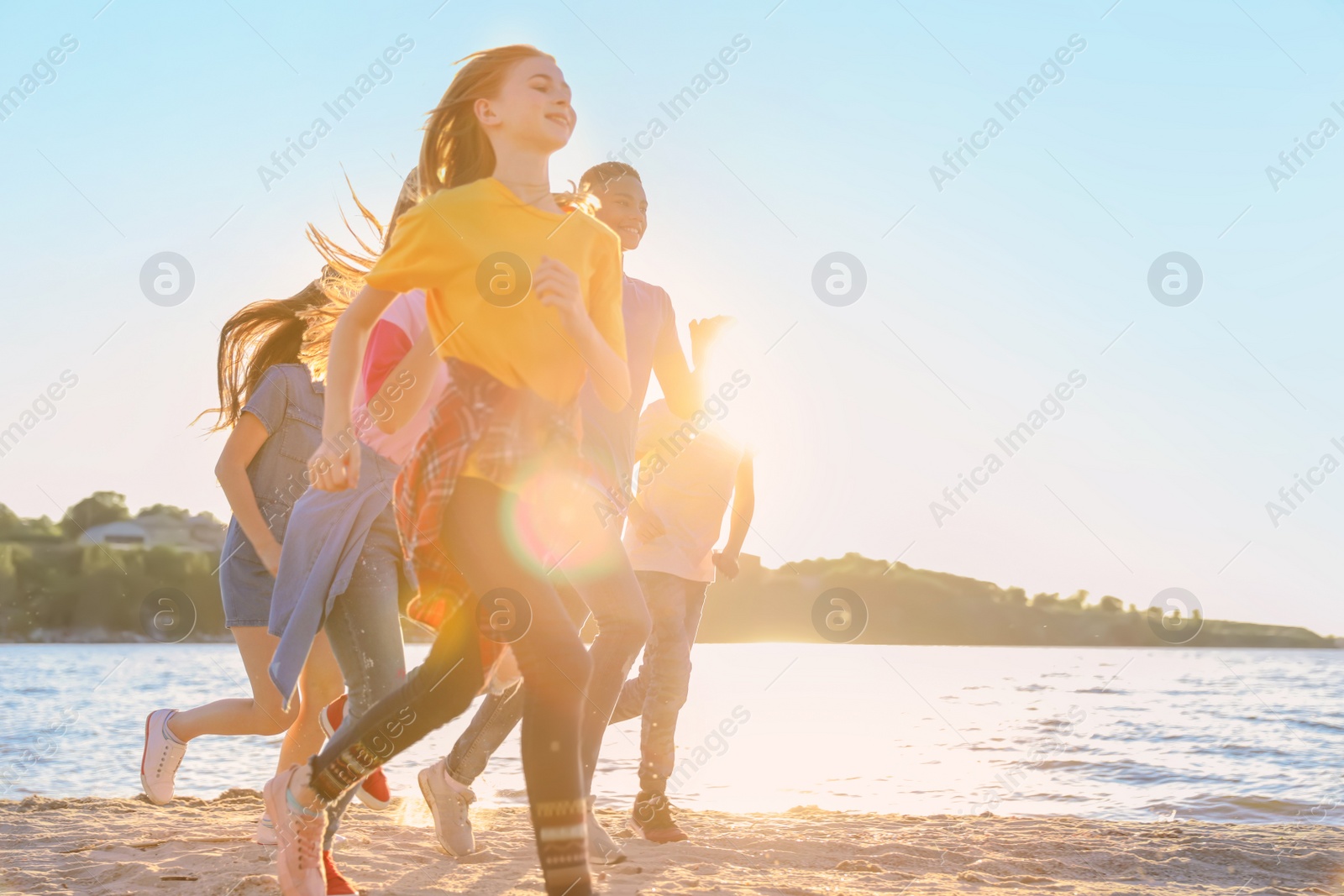 Photo of Group of children running on beach. Summer camp