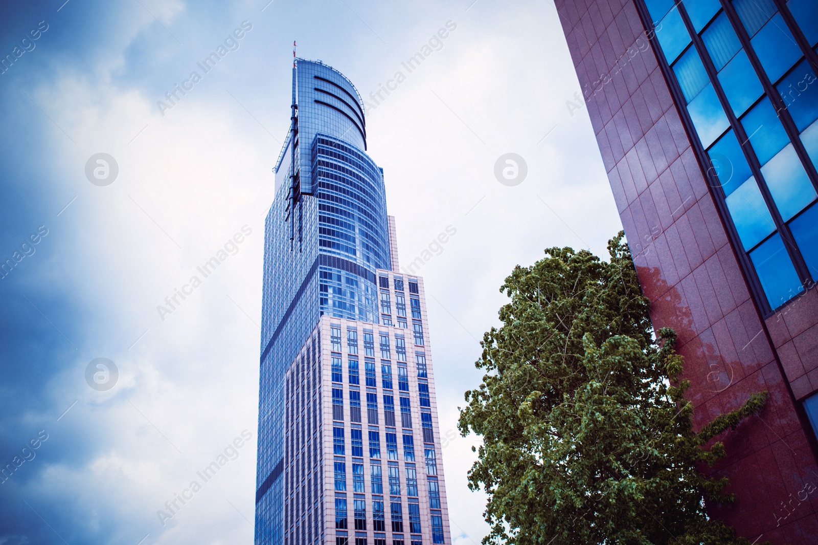 Photo of Beautiful buildings with many windows on cloudy day in city, low angle view