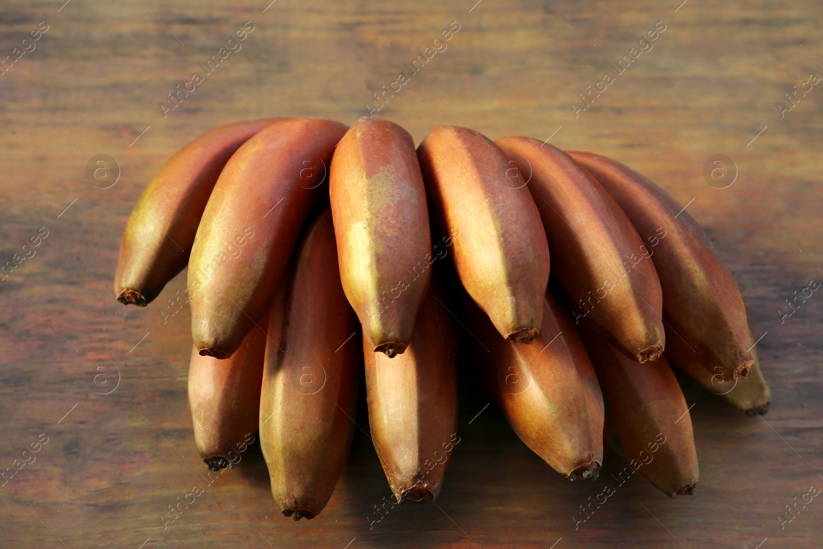 Photo of Tasty purple bananas on wooden table, closeup