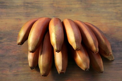 Tasty purple bananas on wooden table, closeup