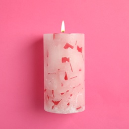 Alight scented wax candle on color background