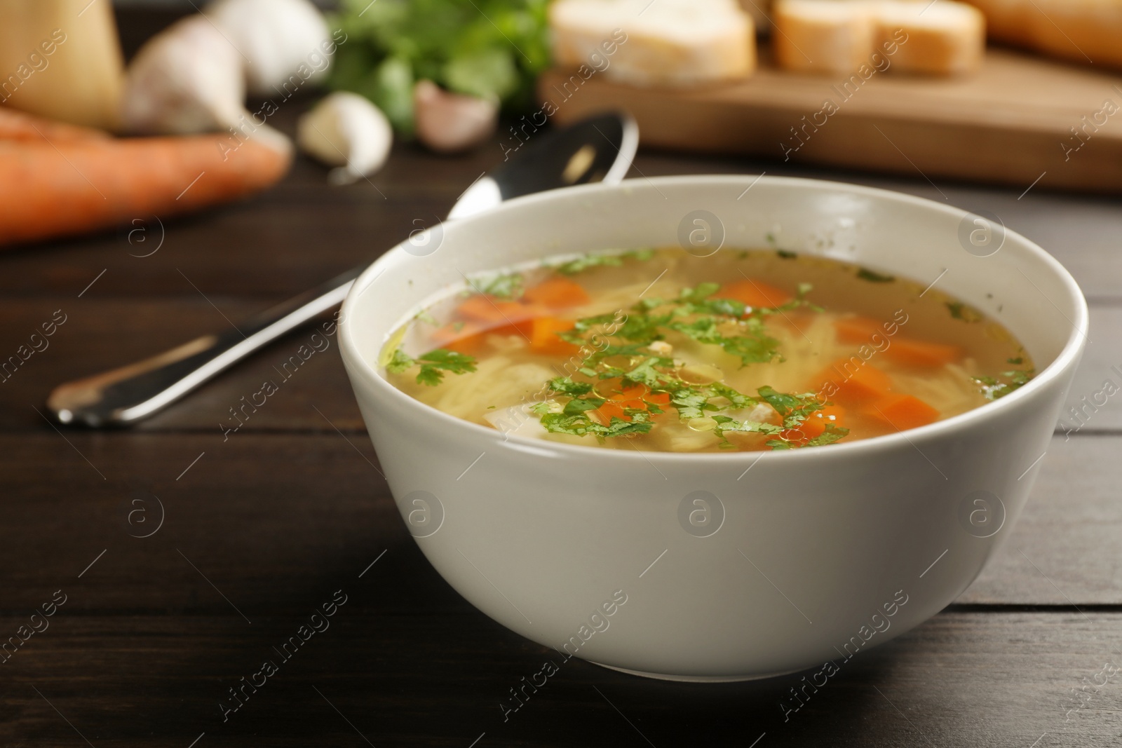 Photo of Bowl with fresh homemade chicken soup on wooden table