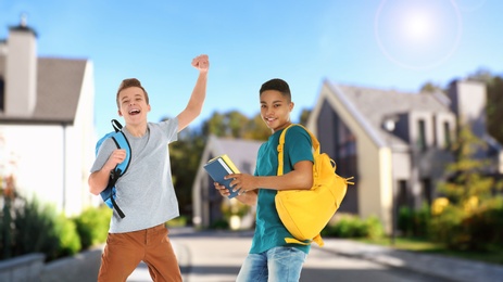 Image of Happy teenage boys on street. School holidays