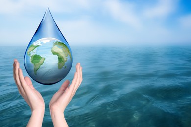 Image of Woman holding icon of Earth in drop near ocean, closeup with space for text. Water save concept