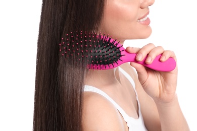 Woman with hair brush on white background, closeup