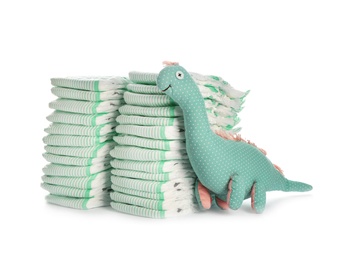 Photo of Disposable diapers and toy dinosaur on white background. Baby accessories