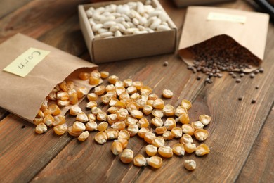 Photo of Different vegetable seeds on wooden table, closeup