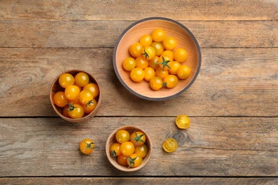 Photo of Ripe yellow tomatoes on wooden table, flat lay