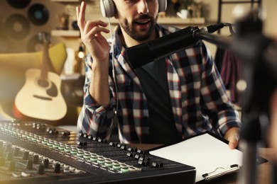 Photo of Man working as radio host in modern studio, closeup