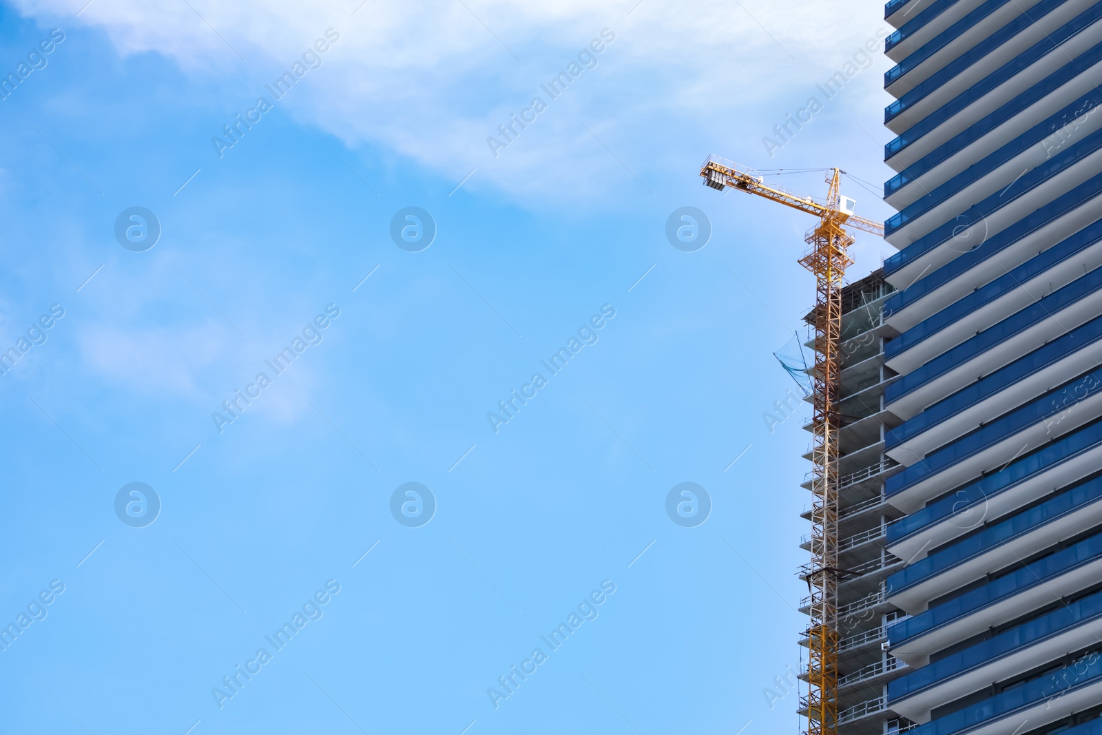 Photo of Construction site with tower crane near unfinished building