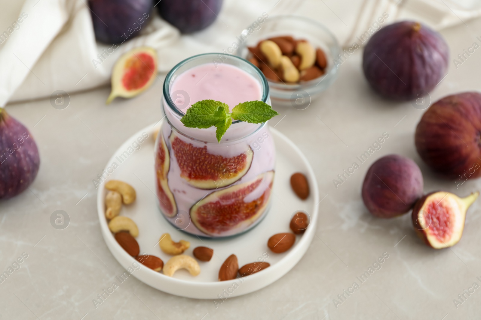 Photo of Delicious fig smoothie in glass jar on light table