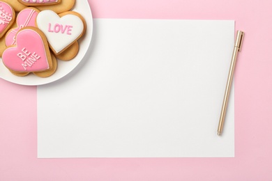 Photo of Flat lay composition with heart shaped cookies and blank sheet of paper on color background, space for text