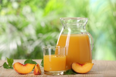 Tasty peach juice and fresh fruit on wooden table outdoors, space for text