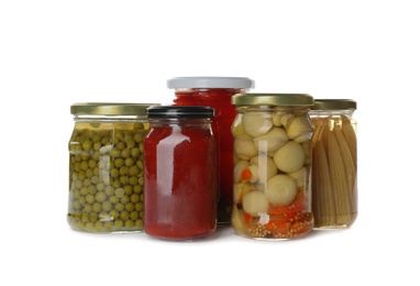 Photo of Glass jars with different pickled vegetables and mushrooms on white background