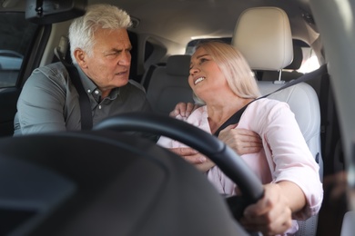 Senior woman having heart attack in car