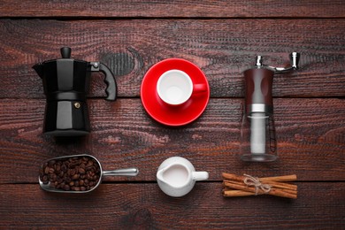 Flat lay composition with manual grinder and geyser coffee maker on wooden background