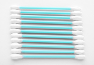 Many clean cotton buds on white background, top view