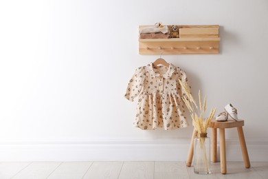 Photo of Cute children's clothes and shoes in room. Space for text