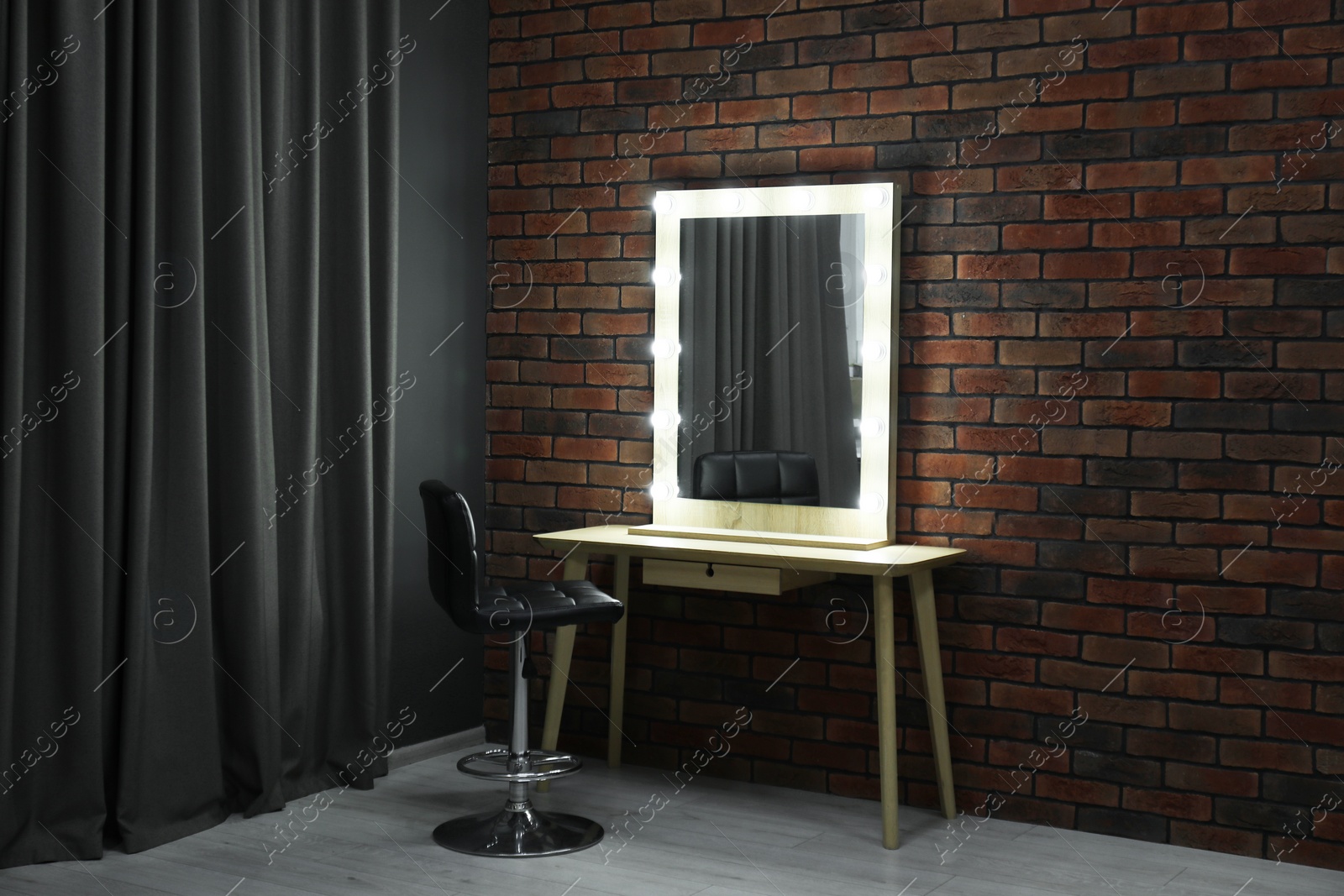 Photo of Mirror with light bulbs, table, chair and curtain in makeup room