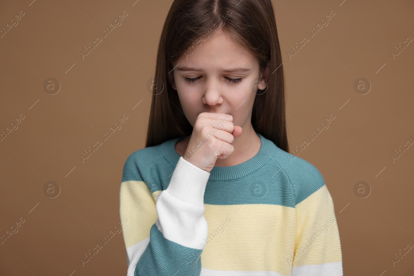 Photo of Sick girl coughing on brown background. Cold symptoms