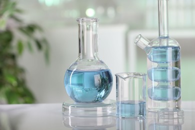 Laboratory analysis. Different glassware with liquid on white table indoors. Space for text