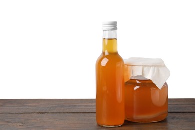 Delicious kombucha in glass bottle and jar on wooden table against white background, space for text