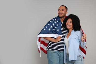 Photo of 4th of July - Independence Day of USA. Happy couple with American flag on grey background, space for text