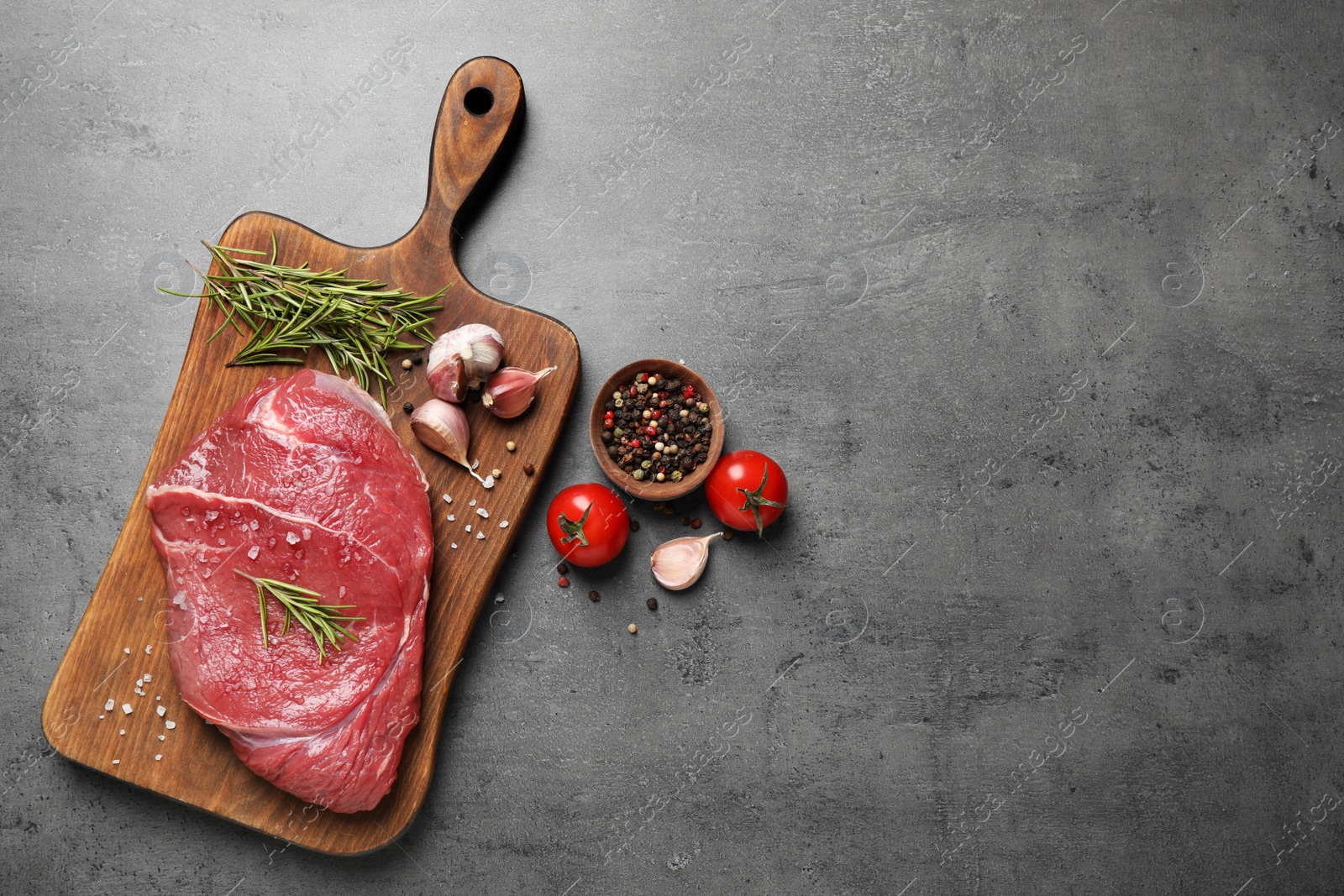 Photo of Flat lay composition with fresh meat on grey table. Space for text