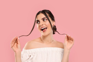 Beautiful woman with elegant jewelry on pink background