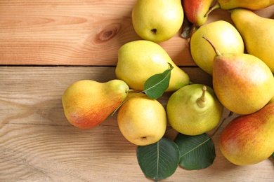 Photo of Ripe pears on wooden background, top view. Space for text