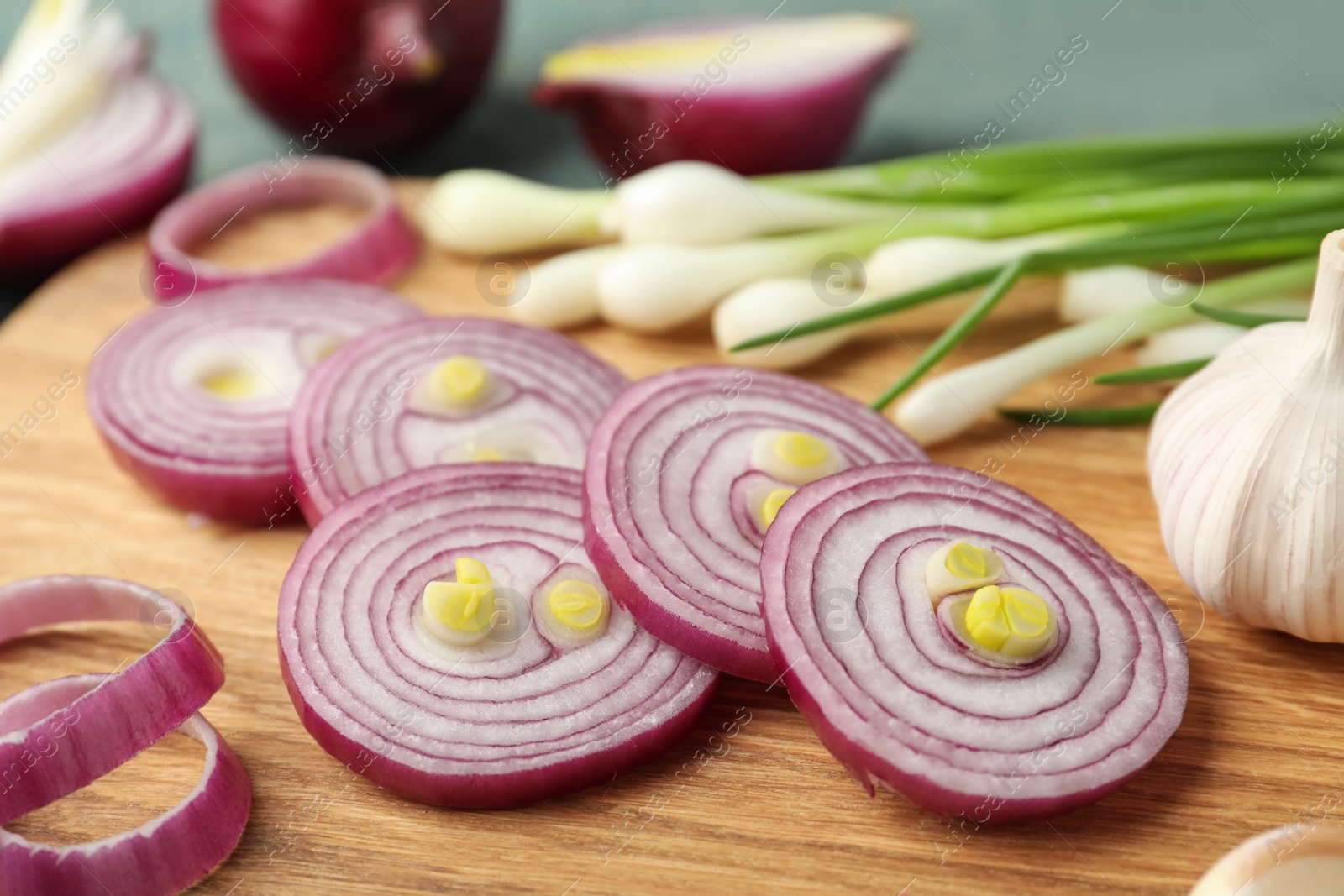 Photo of Cut red onion on wooden board, closeup