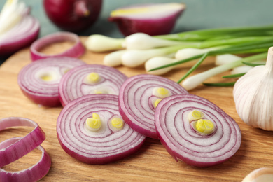 Cut red onion on wooden board, closeup
