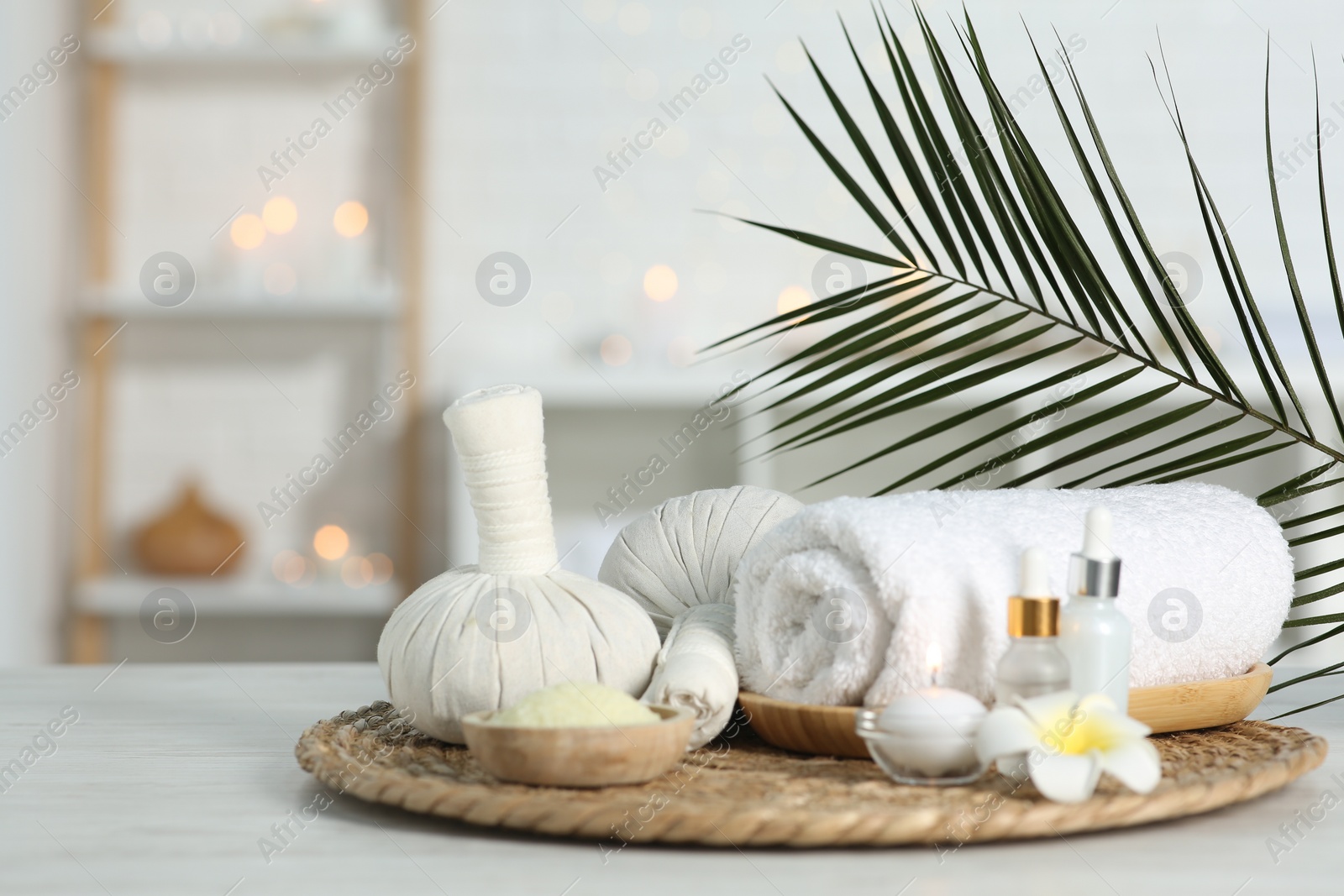 Photo of Composition with different spa products and plumeria flower on white table indoors