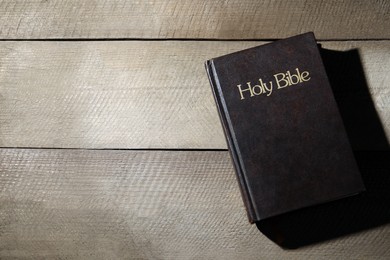 Photo of Holy Bible on wooden table, top view. Space for text