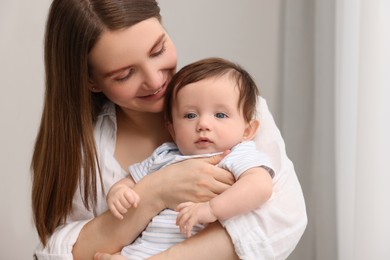 Happy mother with her little baby indoors