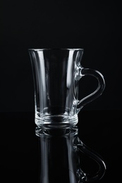 Photo of Clean empty glass mug on black background