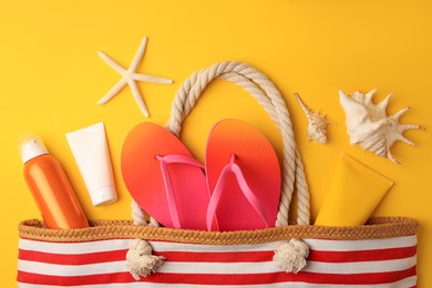 Photo of Flat lay composition with sunscreen and beach accessories on orange background