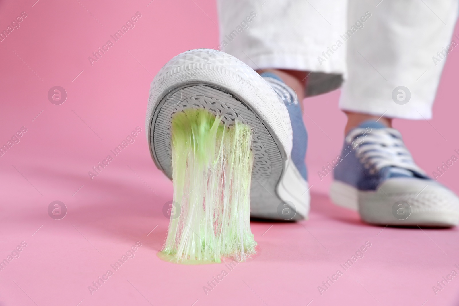 Photo of Person stepping into chewing gum on pink background, closeup