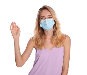 Photo of Woman in protective face mask showing hello gesture on white background. Keeping social distance during coronavirus pandemic