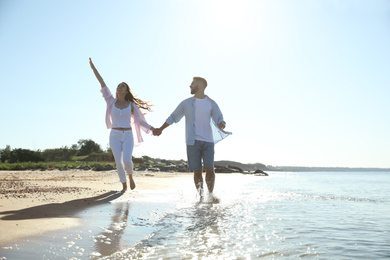 Happy young couple on beach near sea. Honeymoon trip