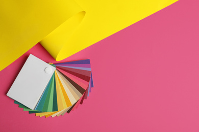 Photo of Color palette and yellow paper on pink background, top view. Space for text