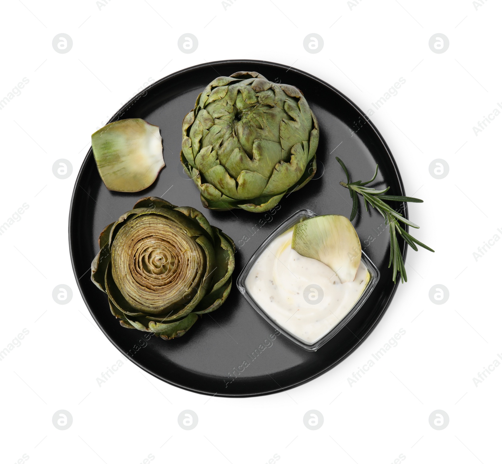 Photo of Delicious cooked artichokes with tasty sauce and rosemary isolated on white, top view